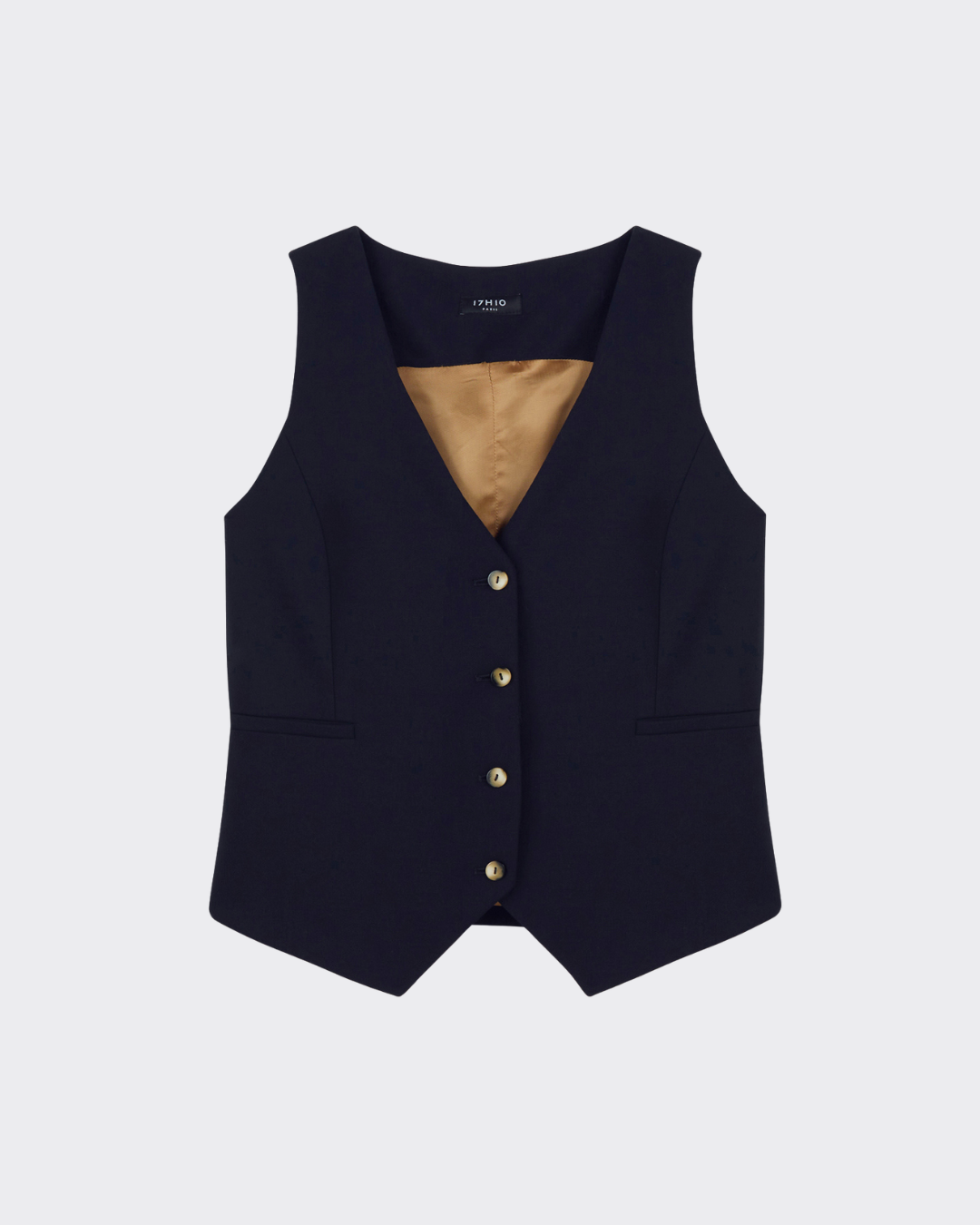 Look business chic femme avec tailleur bleu marine, veste croisée ceinturée, gilet sans manches et pantalon droit.