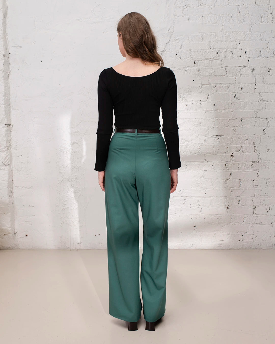 Tenue fiançailles femme avec tailleur vert, veste cintrée et pantalon large pour une silhouette élégante.