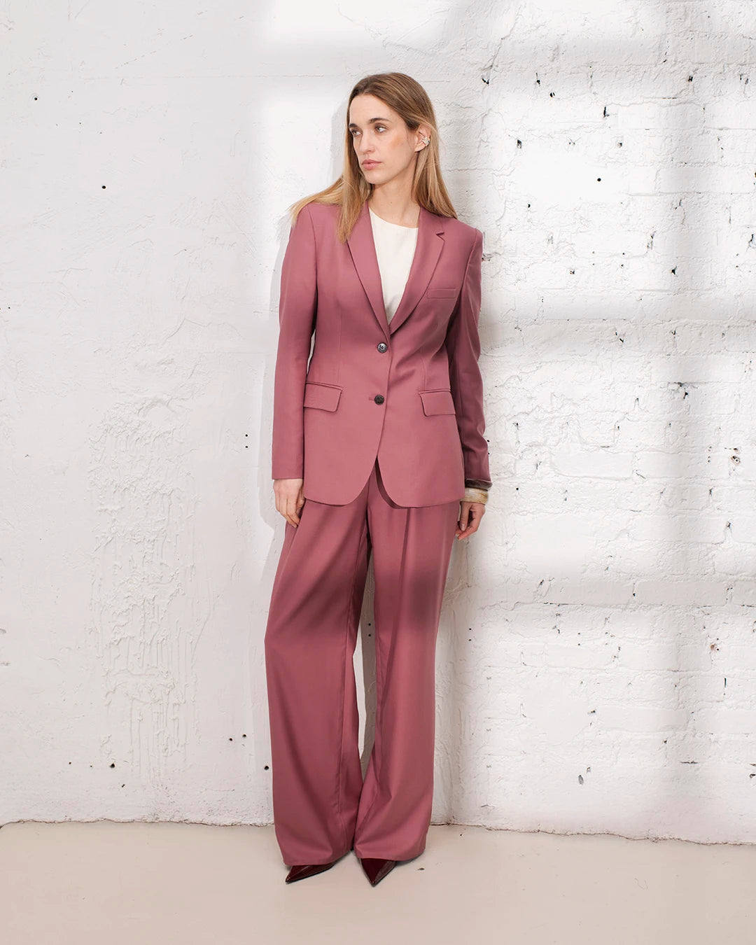 Look soirée femme en tailleur rose avec veste structurée et pantalon palazzo chic