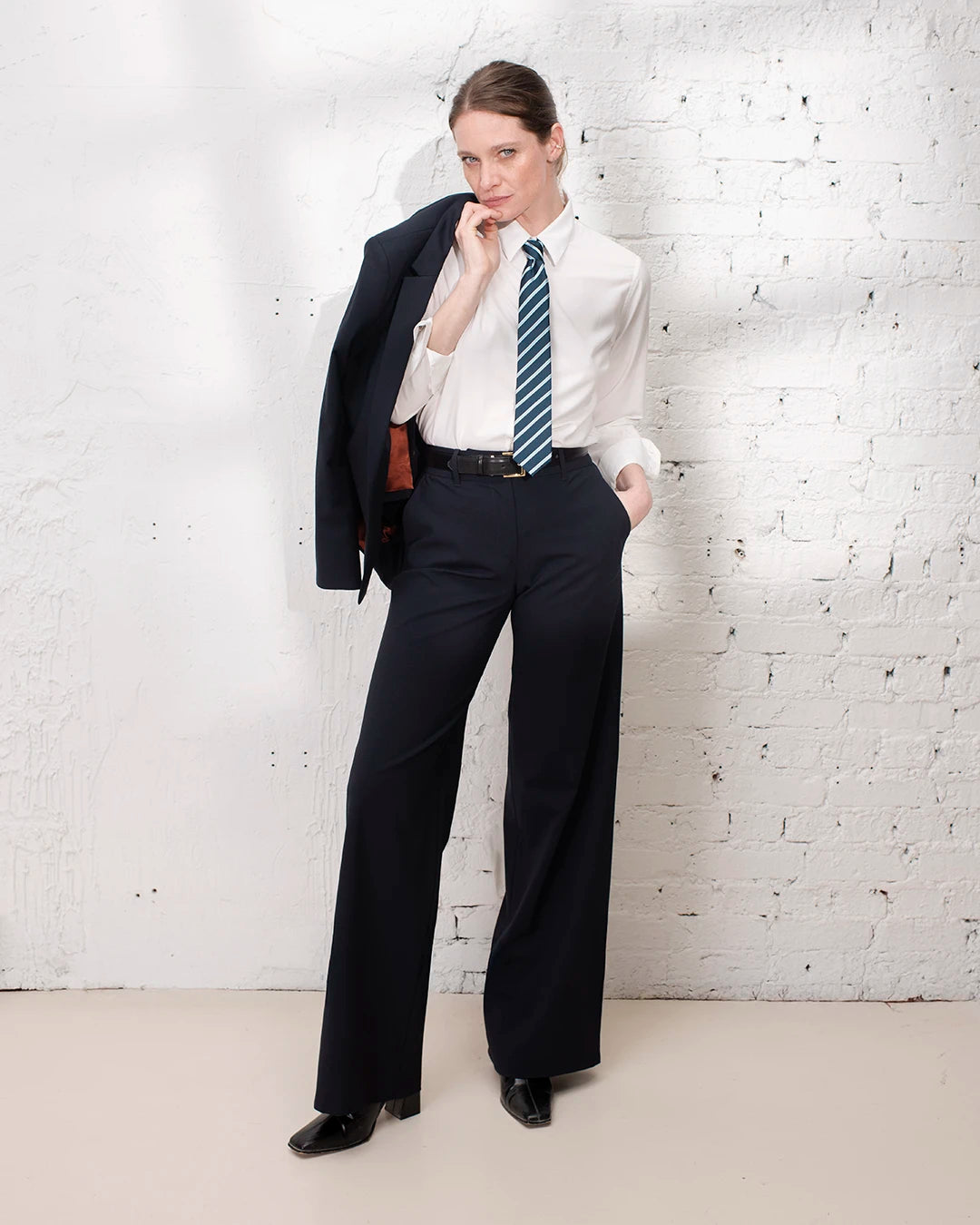 Tenue de bureau femme avec tailleur bleu marine, veste ajustée cintrée et pantalon large élégant