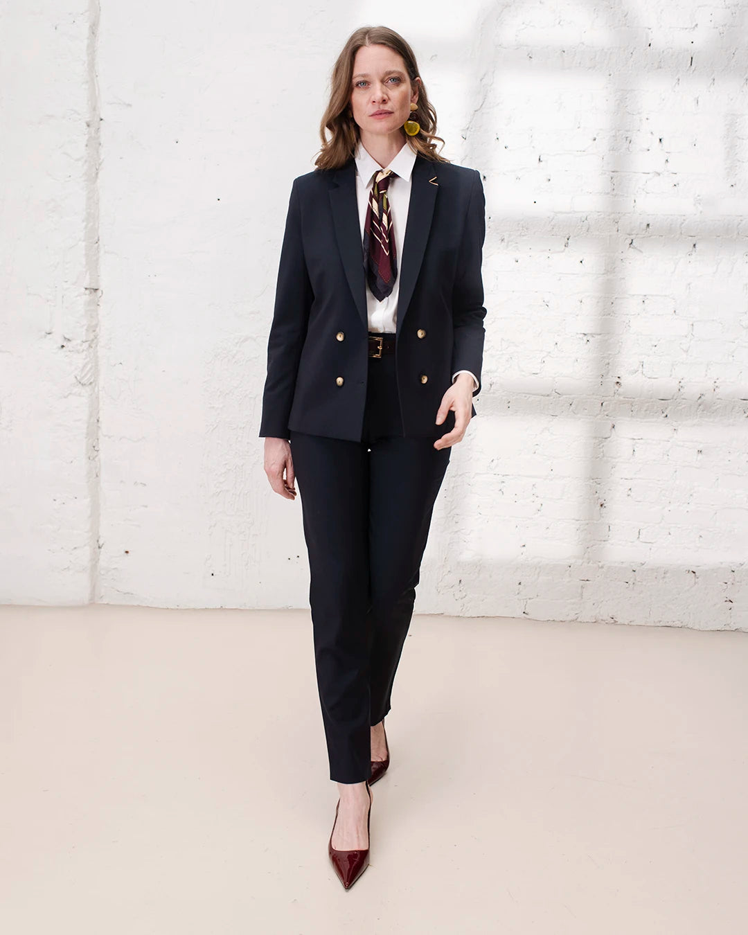 Look business chic femme avec veste croisée bleu marine et pantalon cigarette pour le bureau.