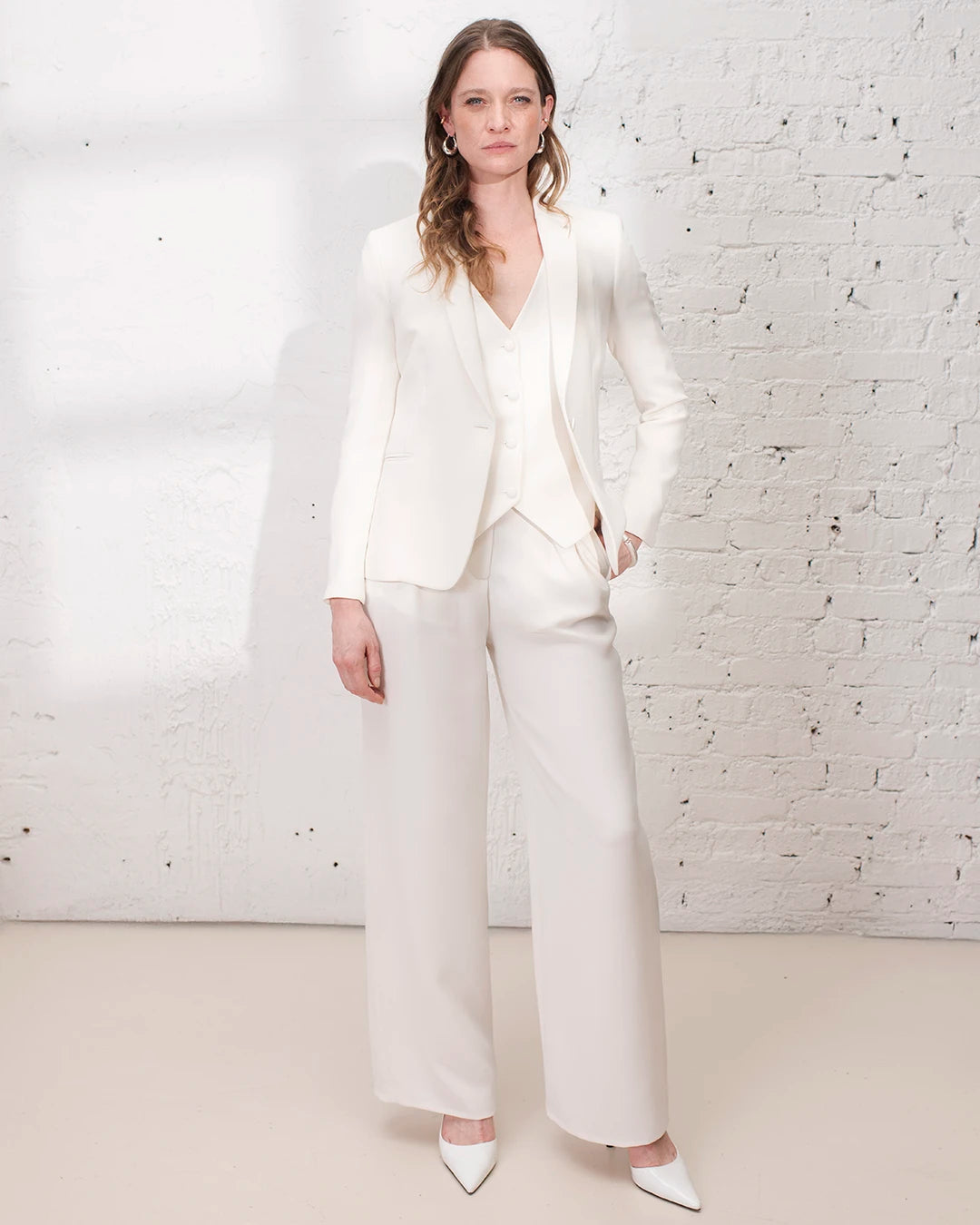 Tailleur blanc mariage civil avec veste cintrée, gilet trois pièces et pantalon large blanc.