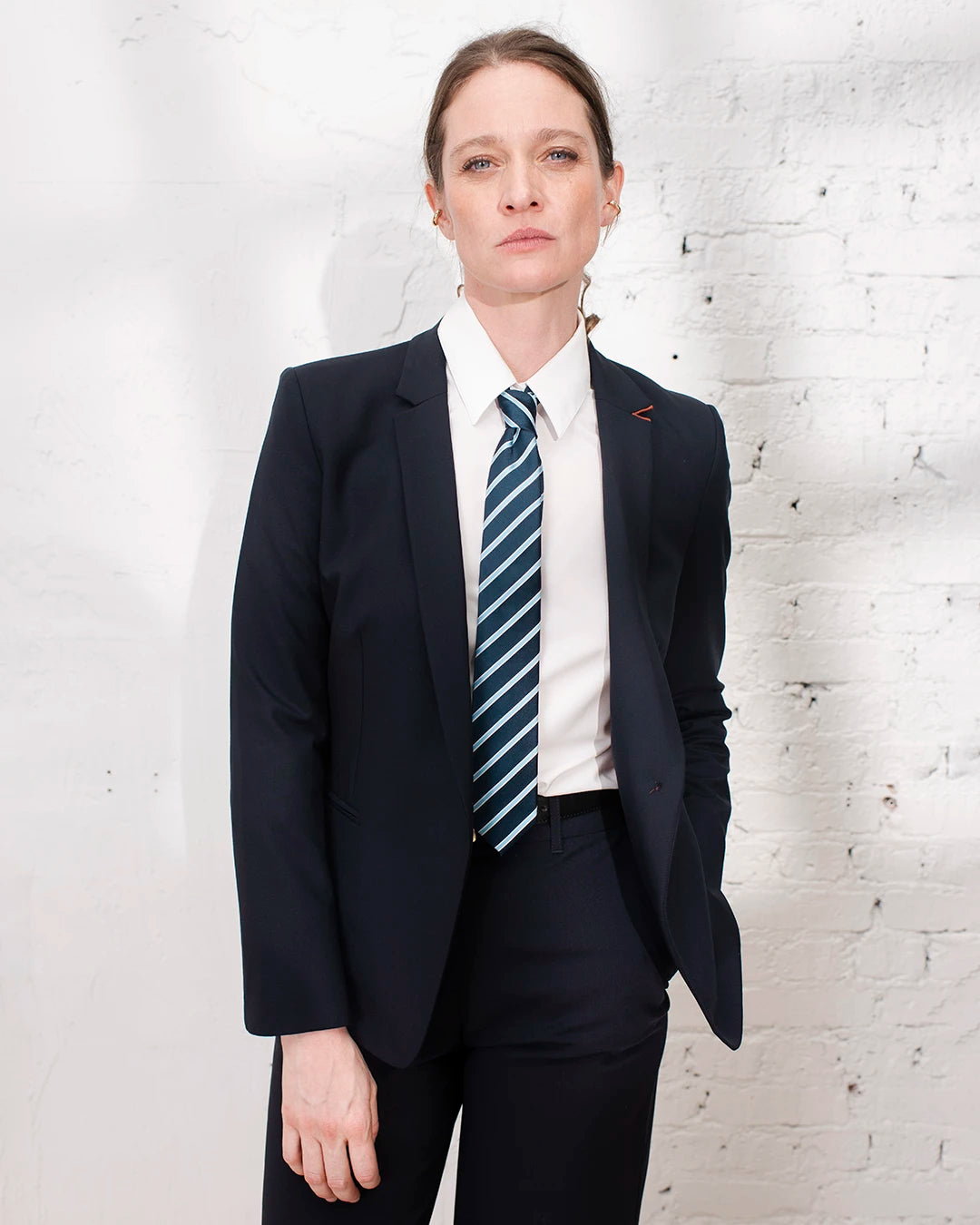 Look élégant pour le travail avec tailleur femme bleu marine et veste cintrée.