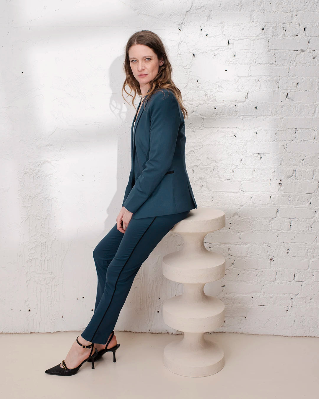 Tailleur femme bleu gris style business avec veste cintrée et pantalon cigarette pour le travail.