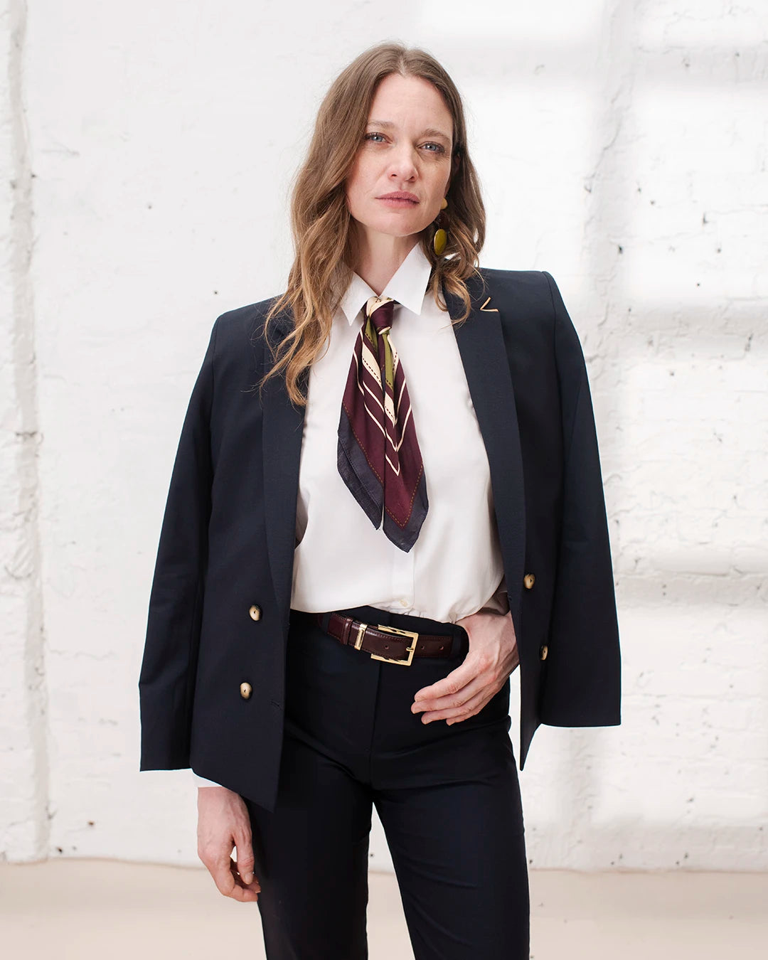 Tenue bureau femme avec tailleur bleu marine, veste croisée chic et pantalon cigarette.