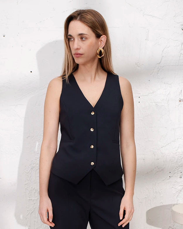 Ensemble tailleur bleu marine trois pièces femme avec veste ceinturée cintrée, gilet et pantalon droit.