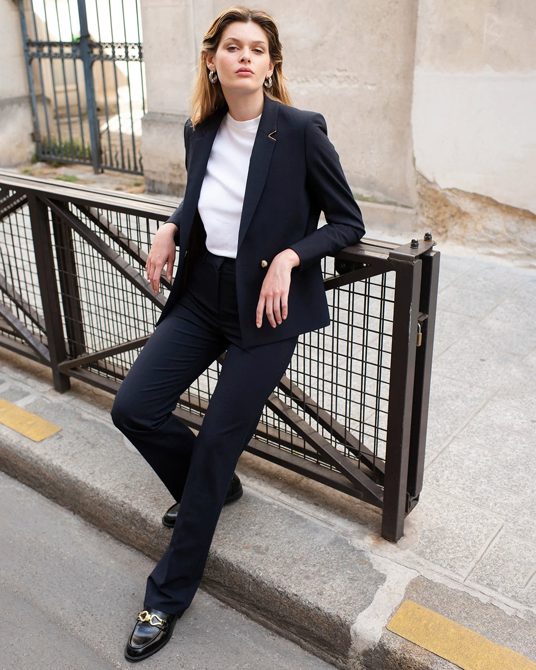 Pantalon-de-tailleur-bleu-marine-Coupe-droite-Taille-haute-Plis-avant-pour-une-tenue-droite-Drap-de-laine-bleu-nuit-Passants-de-ceinture-Fermeture-zip-avec-crochet-Bouton-camel-17H10-tailleurs-pour-femme-paris-