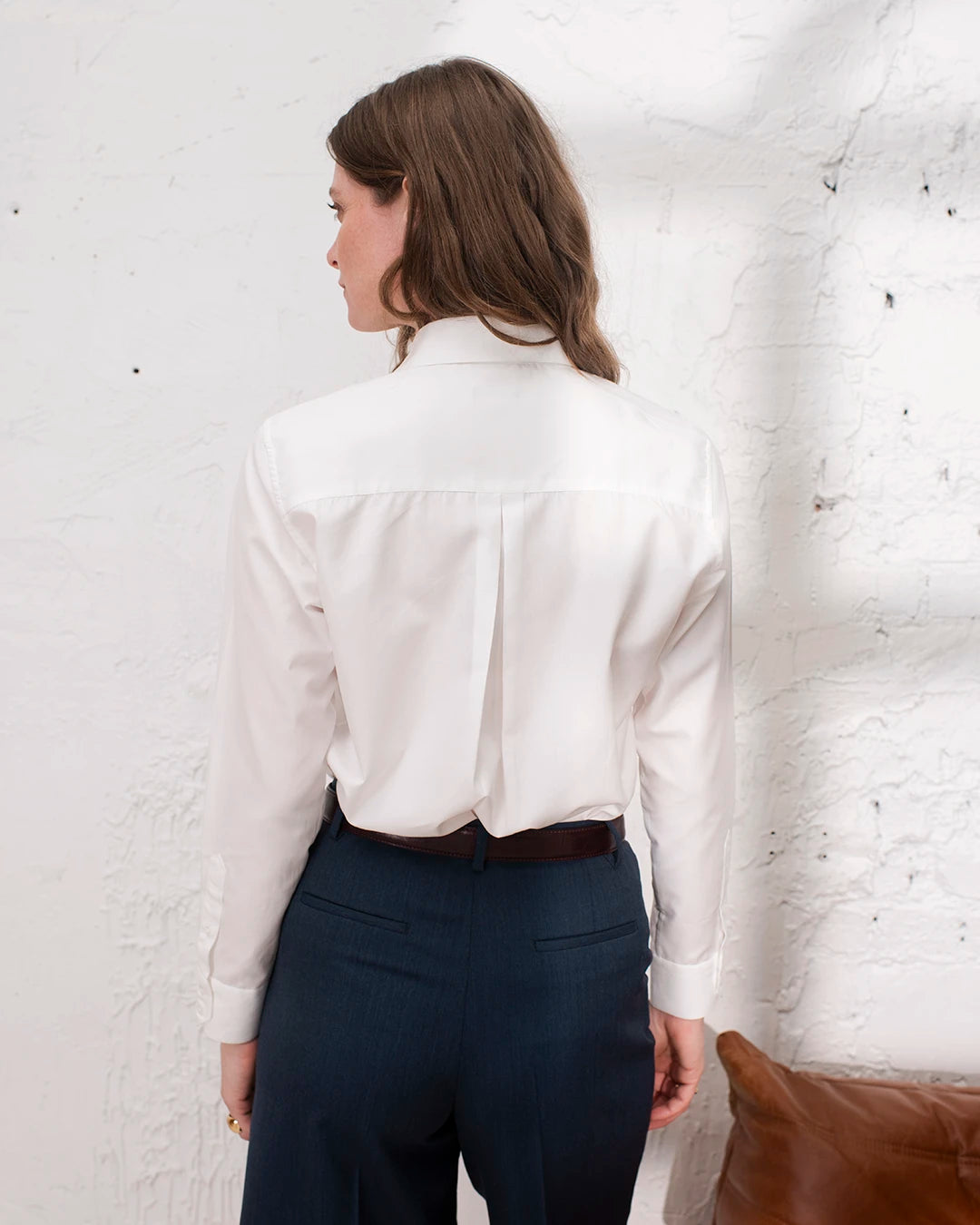 Look de bureau chic femme avec chemise blanche classique et boutons de manchette.