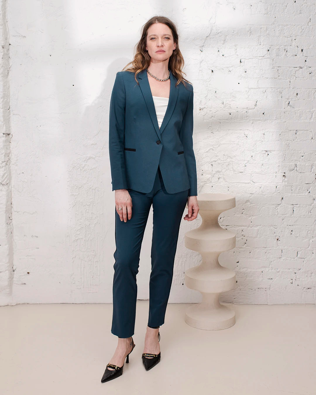 Tailleur bleu gris femme avec veste cintrée et pantalon cigarette pour une tenue de bureau élégante.