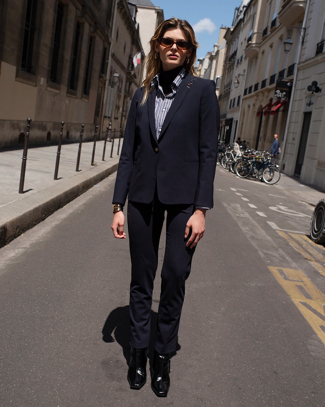 "Pantalon-tailleur-bleu-marine-Coupe-cigarette-Taille-mi-haute-Fausses-poches-cavalières-à-l'avant-Poches-poisepoilées-arrières-Passant-pour-la-ceinture-Fermeture-à-zip-et-à-crochet-Boutons-camel-17H10-tailleurs-pour-femme-paris-"
