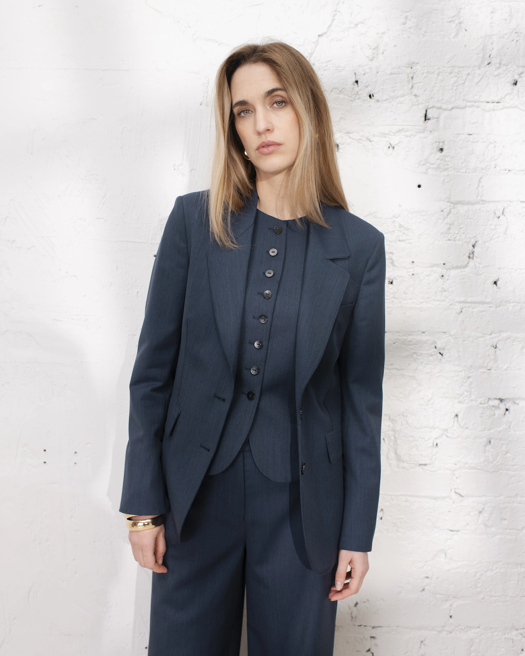 Outfit travail femme avec tailleur denim, veste large et gilet sans manches chic pour une allure élégante.