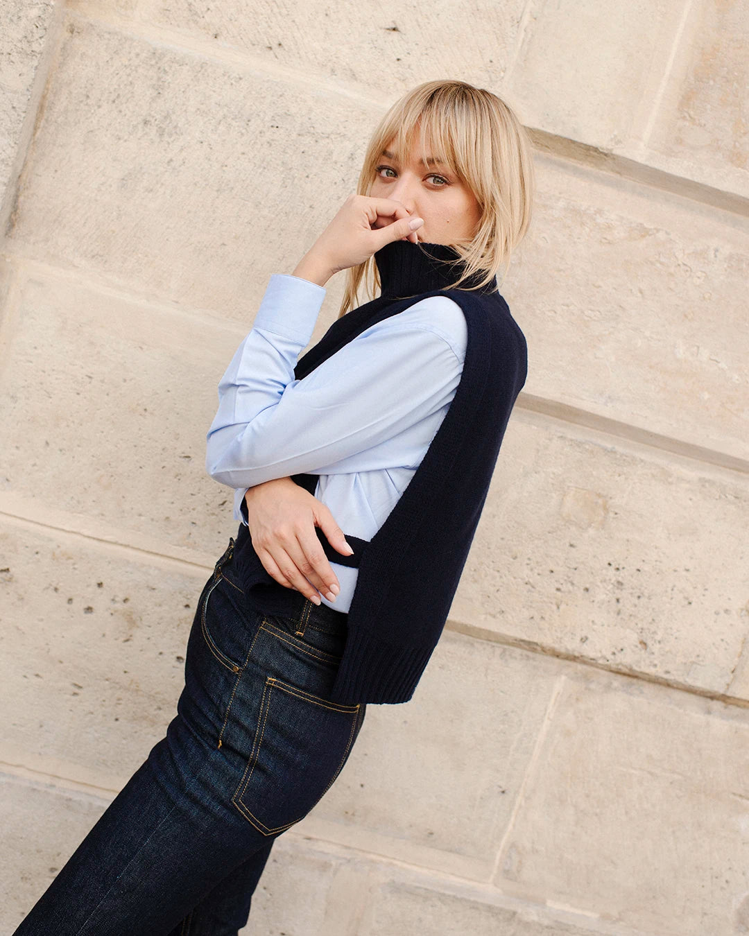 layering-femme-chic-pull-sans-manches-sur-chemise-bleue-avec-jean-brut-coupe-flare-4