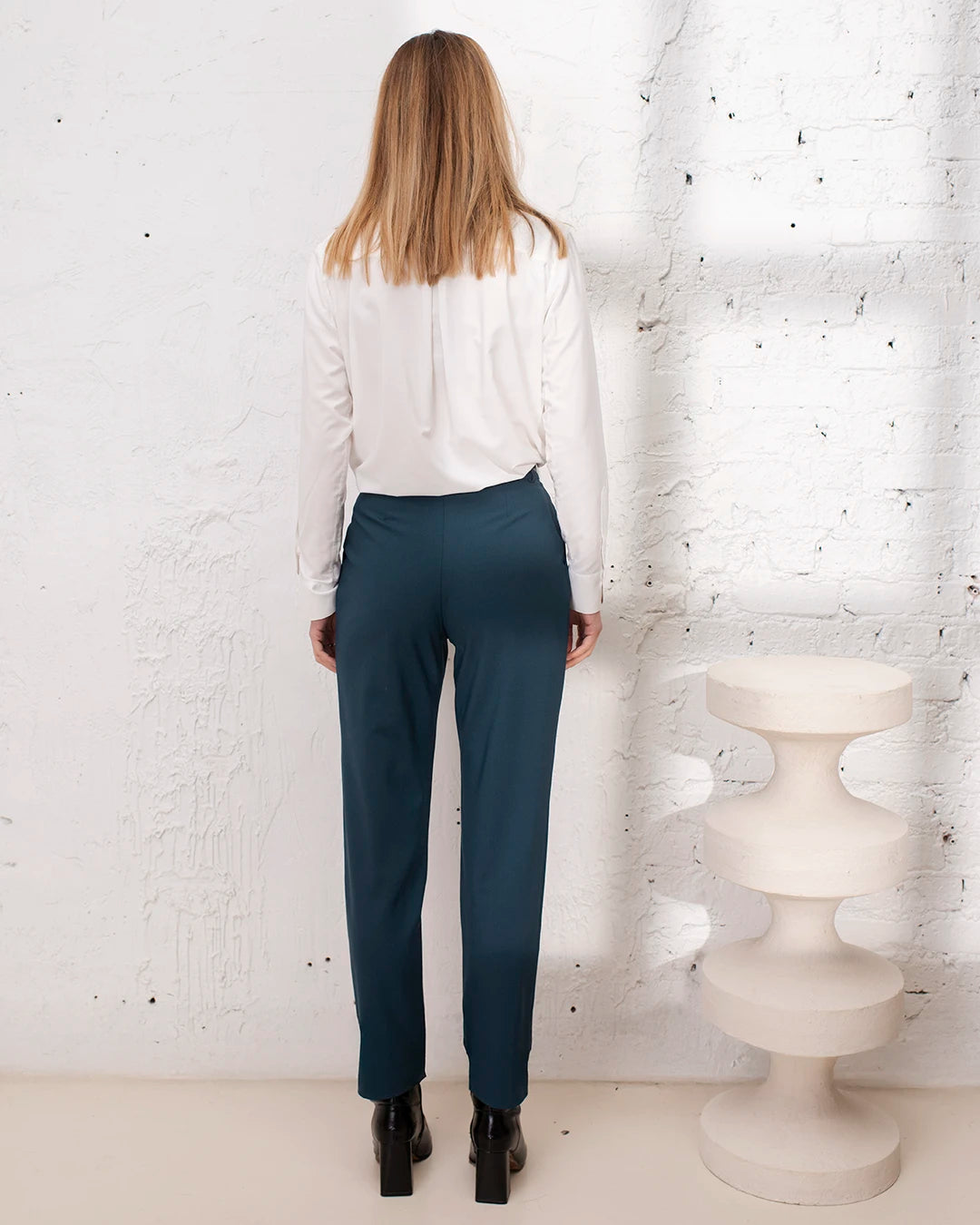 Tenue professionnelle femme bleu gris avec veste croisée et pantalon carotte élégant.
