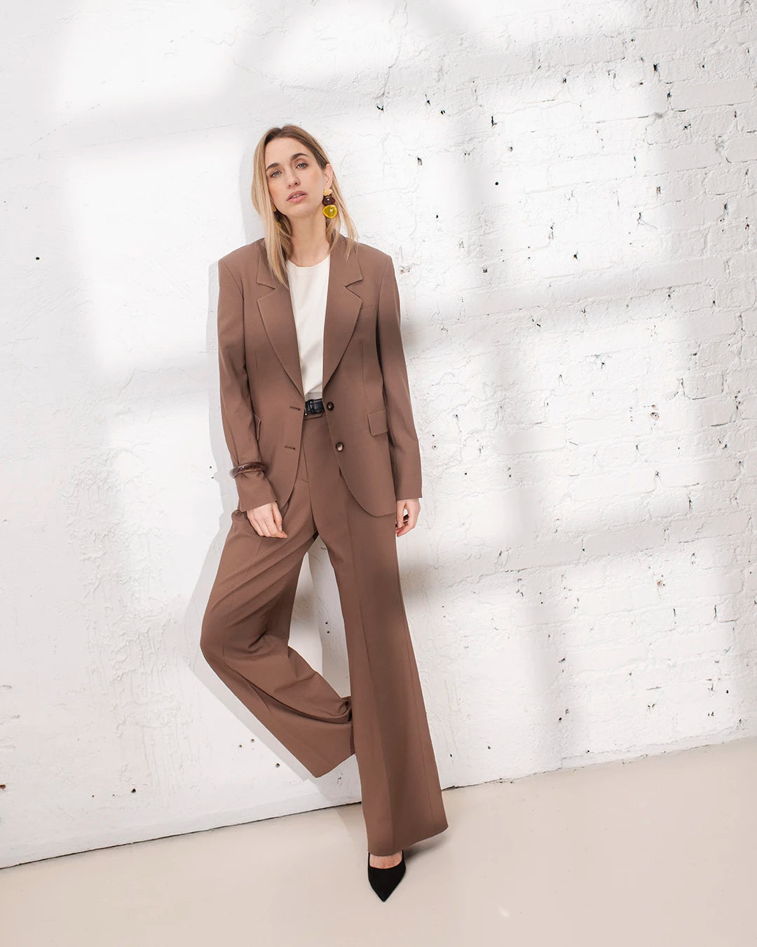 Tenue cérémonie femme avec tailleur marron, veste oversize et pantalon large pour une allure sophistiquée.