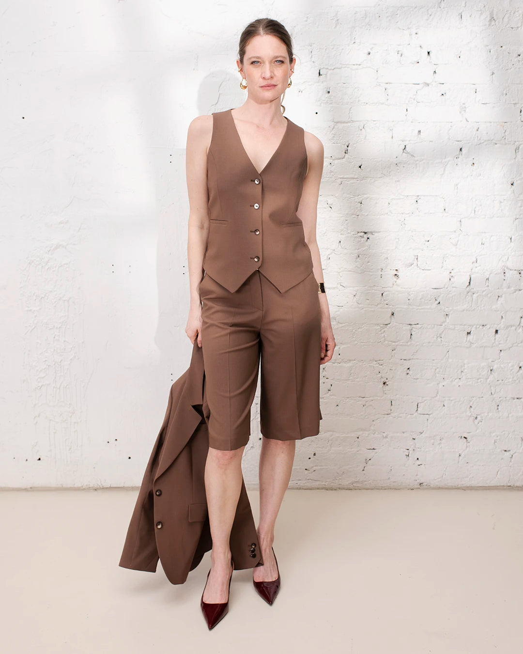 Bermuda habillé marron femme avec gilet trois pièces et veste de tailleur pour une tenue chic.