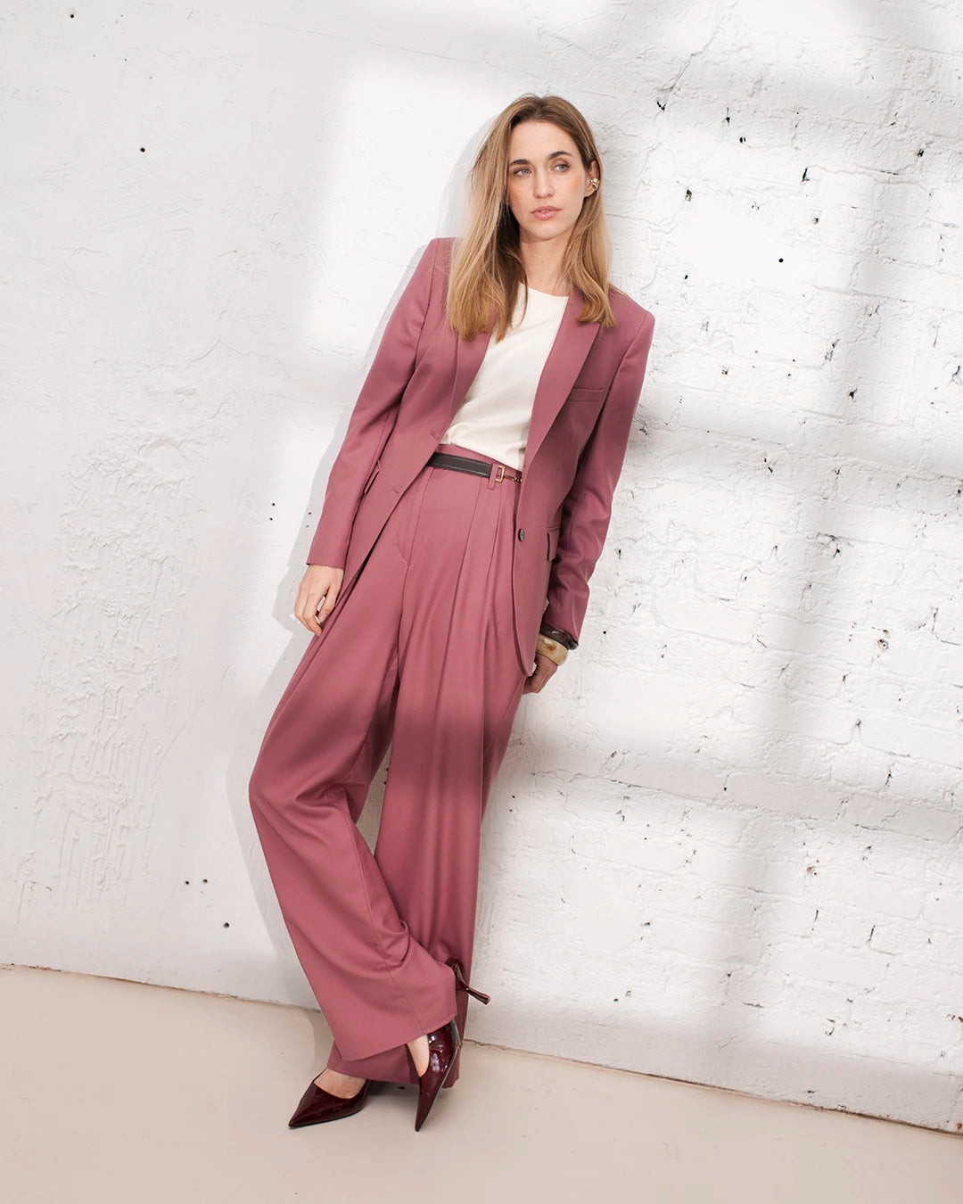 Look soirée femme en tailleur rose avec veste structurée et pantalon palazzo chic
