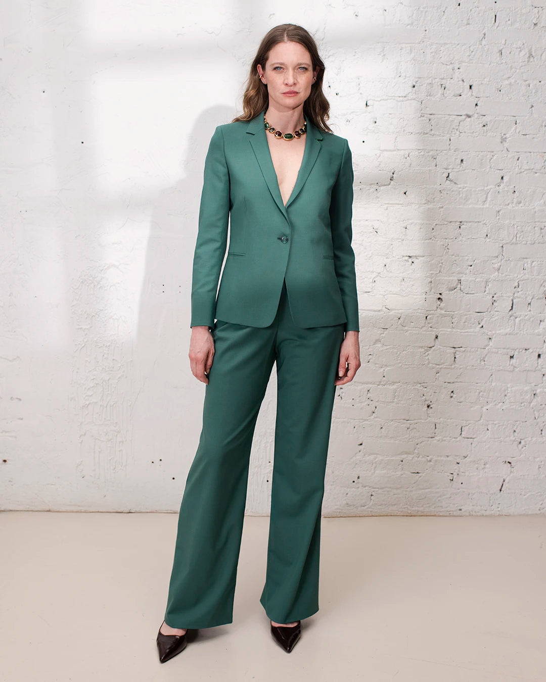 Tailleur vert femme avec veste cintrée et pantalon large, parfait pour un baptême ou une cérémonie.
