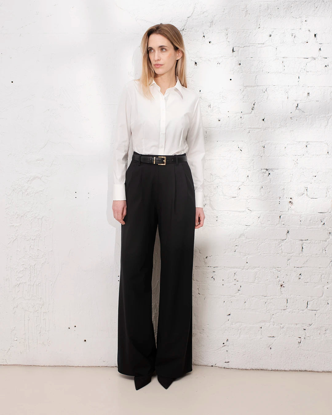 Pantalon large noir femme avec chemise blanche cintrée pour un look bureau élégant