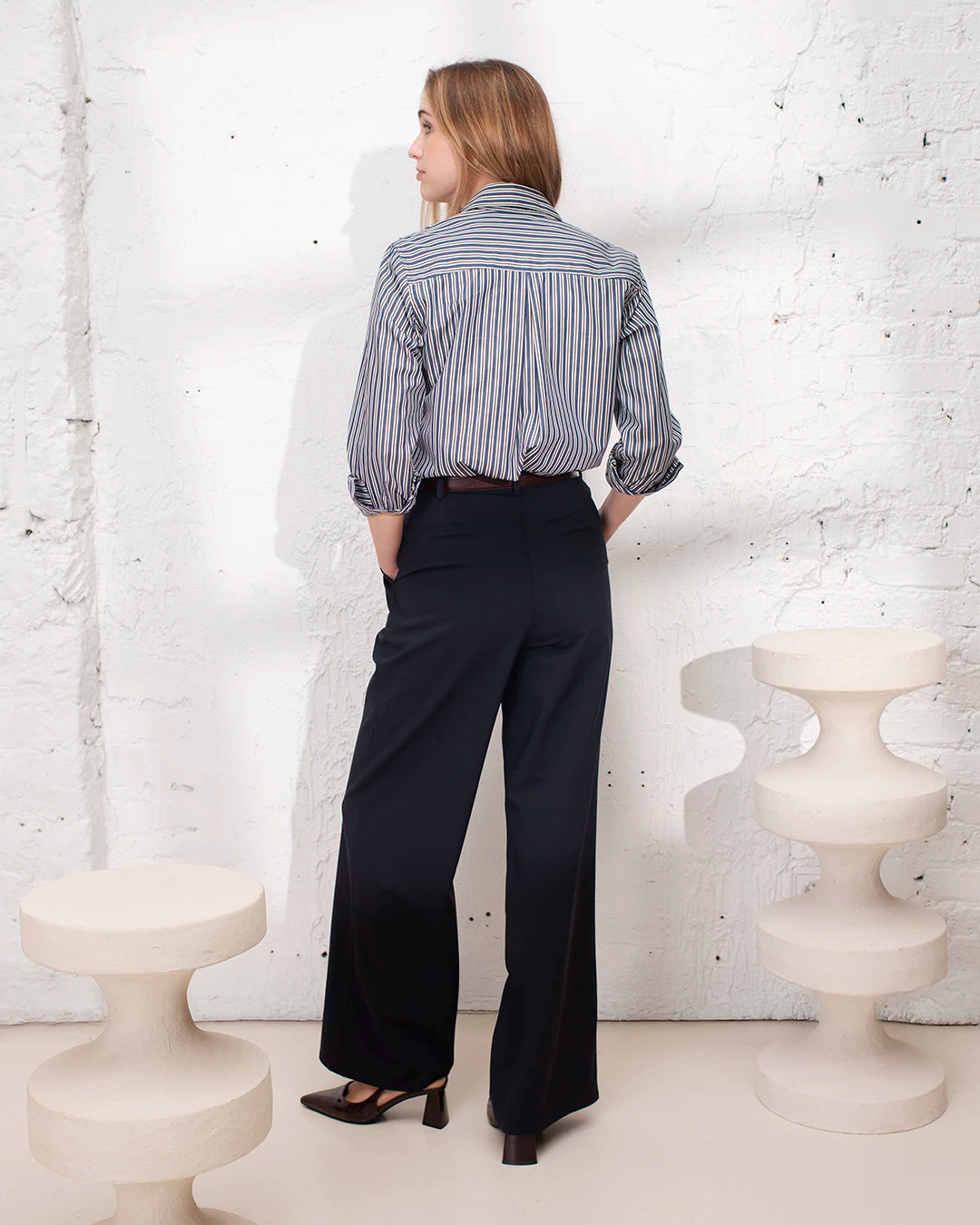 Tenue professionnelle femme bleu marine avec veste courte structurée et pantalon palazzo élégant.