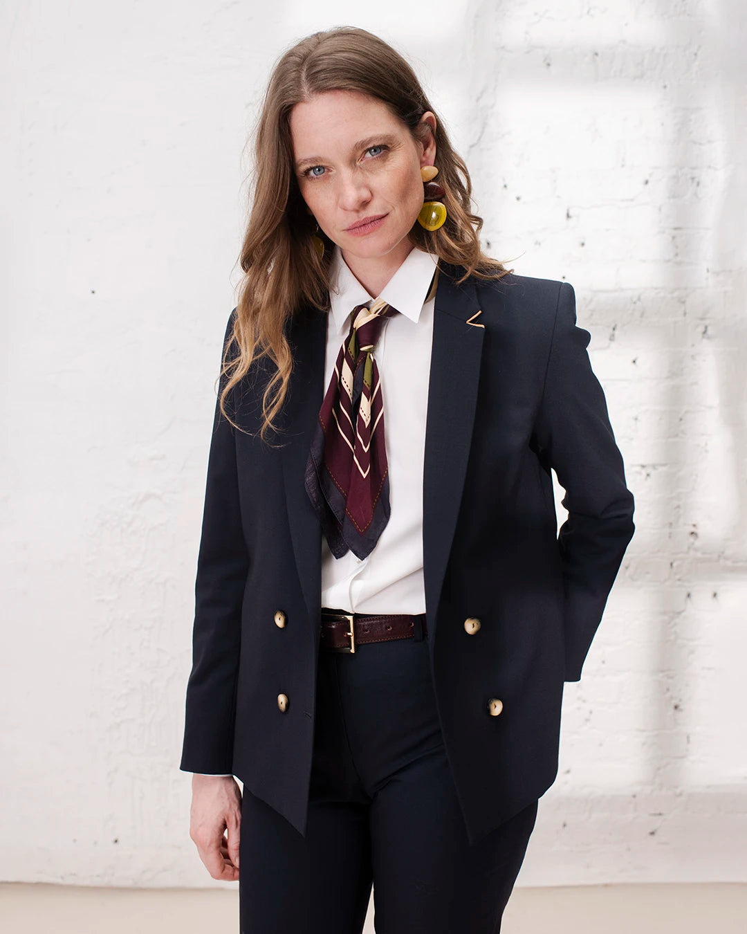 Tailleur femme bleu marine avec veste croisée et pantalon cigarette pour une tenue de bureau élégante.