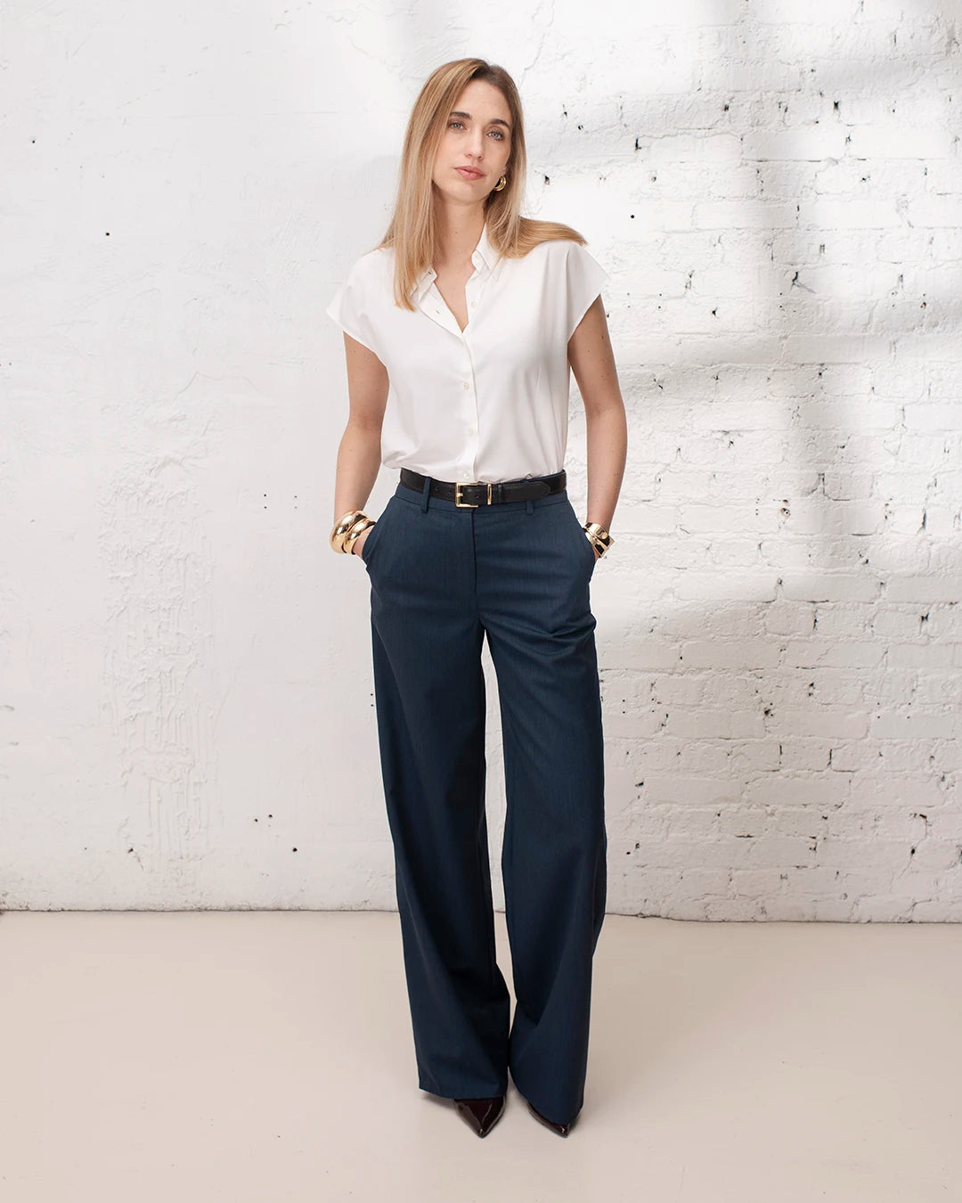 Outfit travail femme avec tailleur denim, veste large et gilet sans manches chic pour une allure élégante.