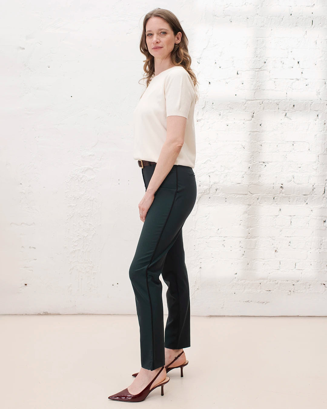 Veste croisée femme portée avec chemise blanche et pantalon cigarette pour une tenue de travail chic.