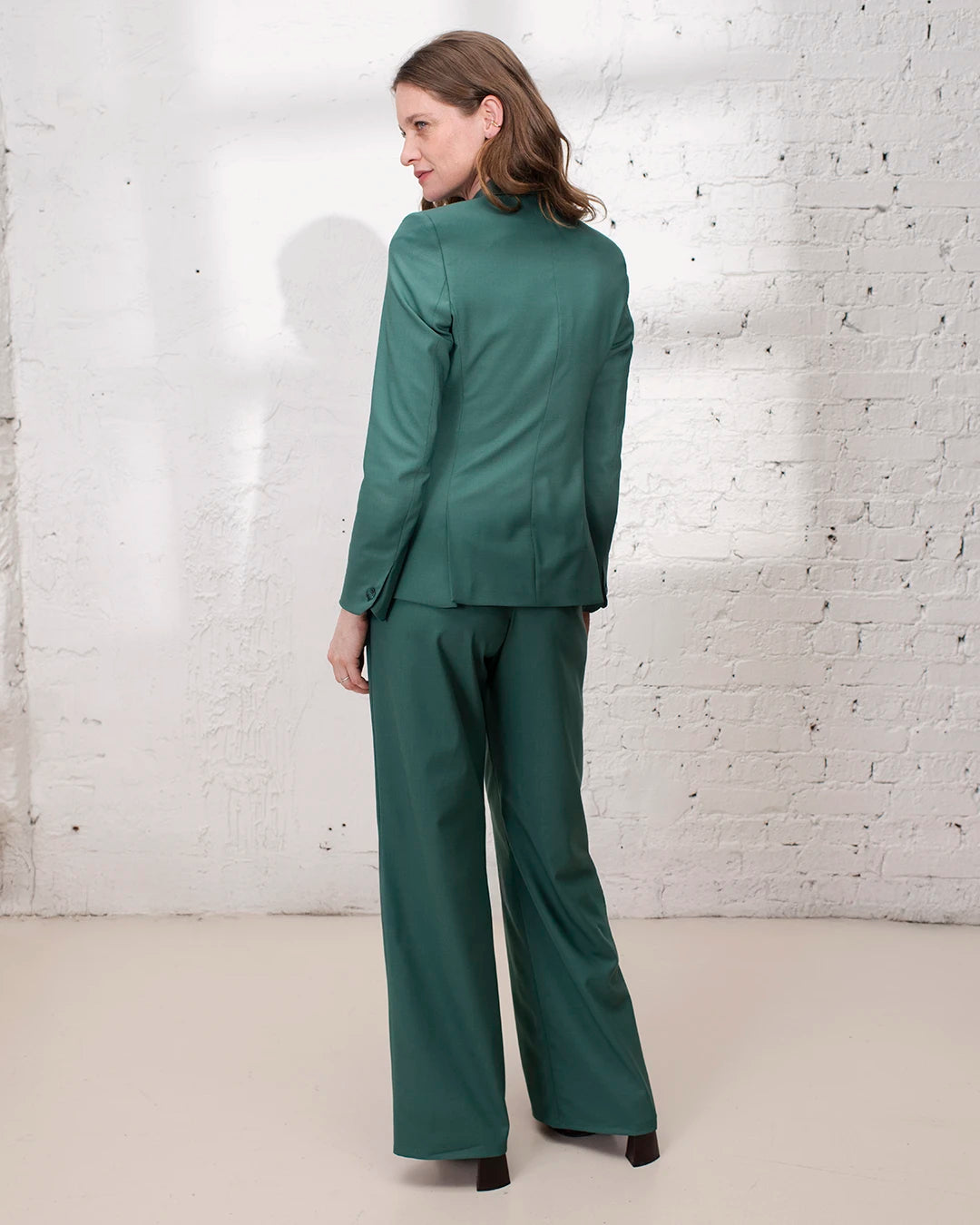 Look élégant femme pour mariage ou cérémonie avec tailleur vert, veste cintrée et pantalon large.