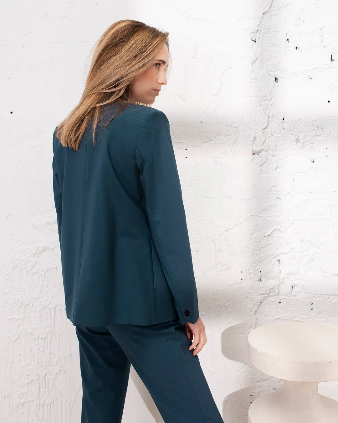 Tailleur femme bleu gris avec veste croisée et pantalon carotte pour un style bureau chic.